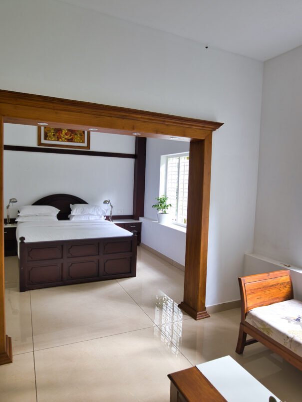 Bedroom view of the Grand Villa at Softouch Ayurveda Village, Kerala, featuring an attached living room, providing a spacious and comfortable stay