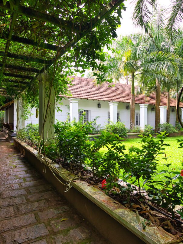 Exterior view of the Grand Villa at Softouch Ayurveda Village, Kerala, showcasing lush green lawns, privacy, and a scenic walkway, offering a serene and spacious retreat
