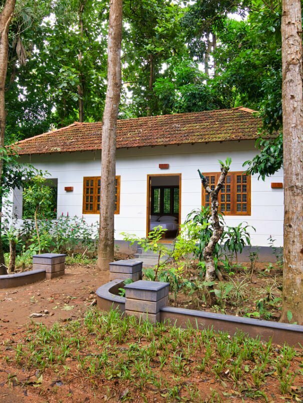 Exterior view of a private unit, a Grand Cottage at Softouch Ayurveda Village, Kerala, nestled in a lush garden and conveniently located next to the Ayurveda centre, offering a secluded and tranquil retreat
